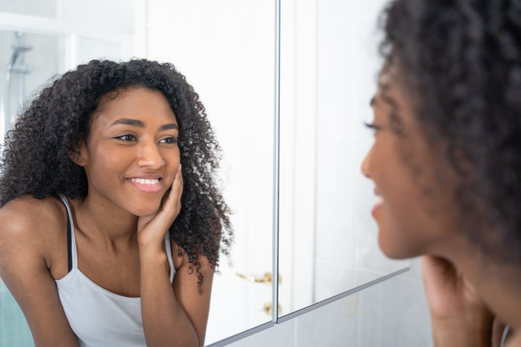 A Black woman admiring her beauty